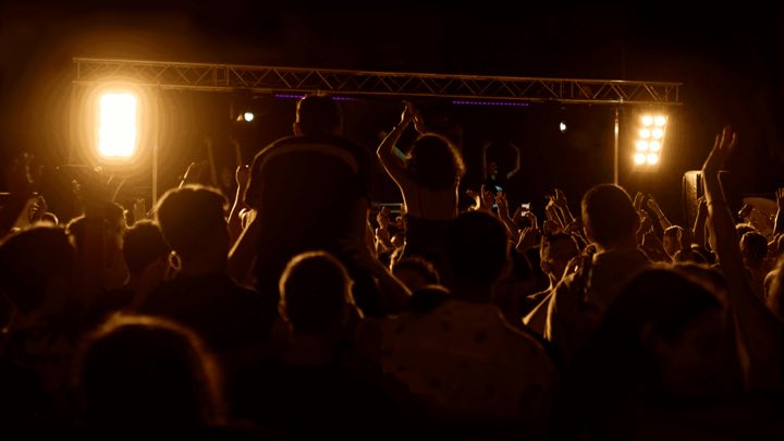 Palco illuminato con pubblico durante un evento pubblico